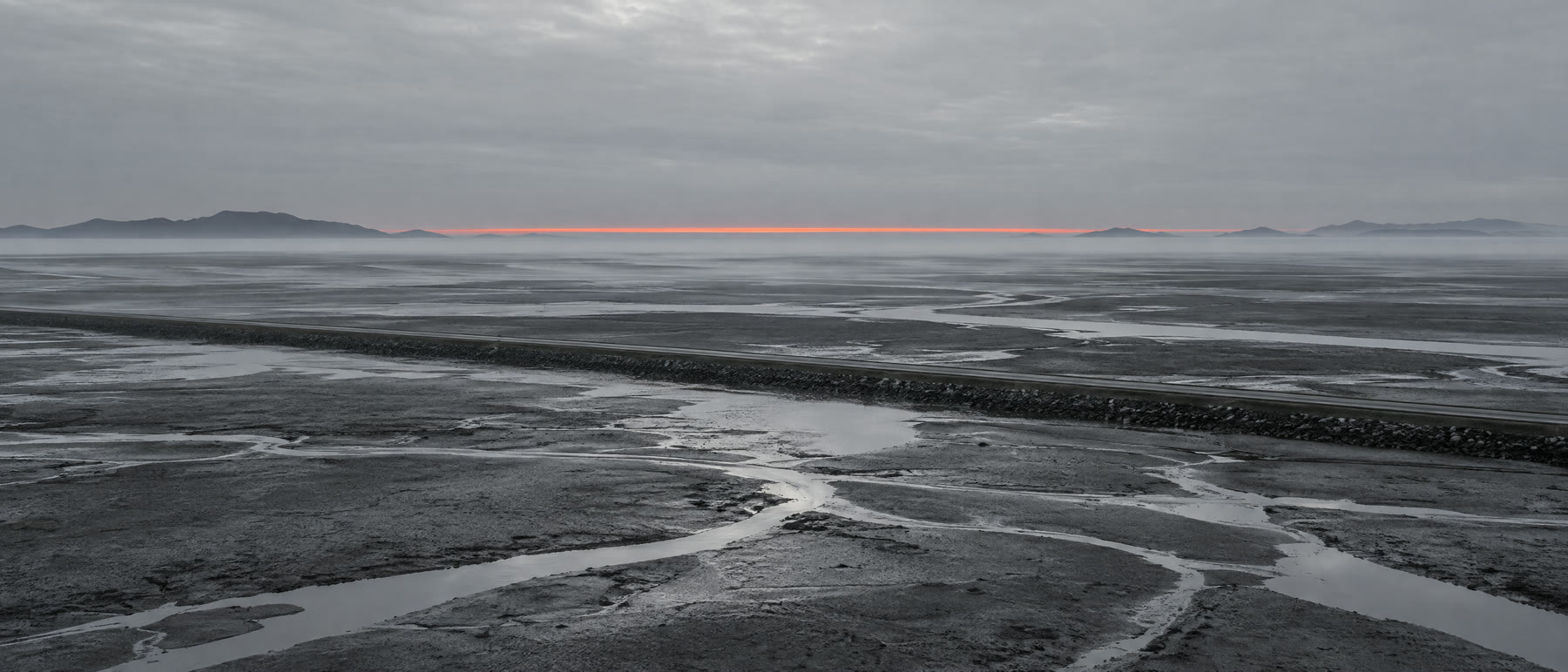 Concept still of flat land beside tidal mudflats at dawn